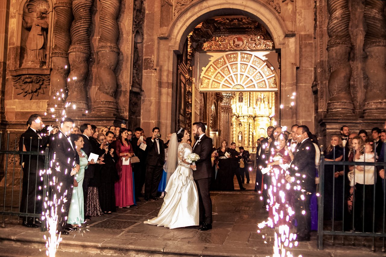 Couple exiting La Compañía de Jesús church in Quito Ecuador at night after their wedding ceremony