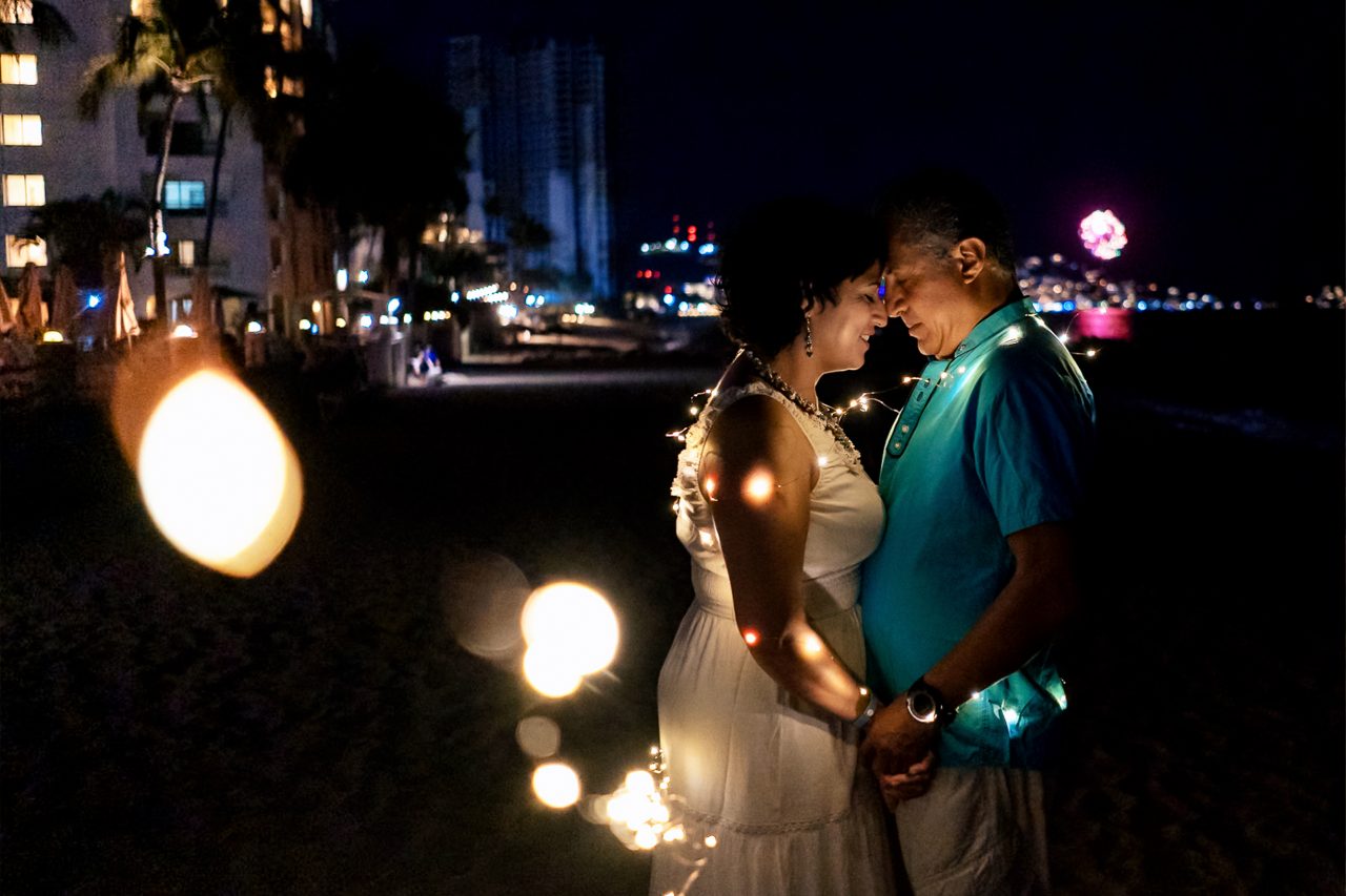 Couple walking at night on the beach in Sayulita Mexico with artificial lighting and cinematic atmosphere