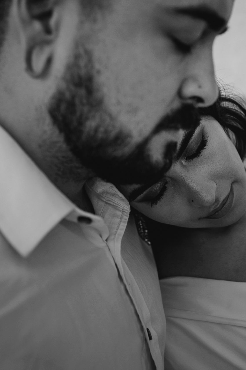 Black and white intimate wedding moment bride resting on groom shoulder
