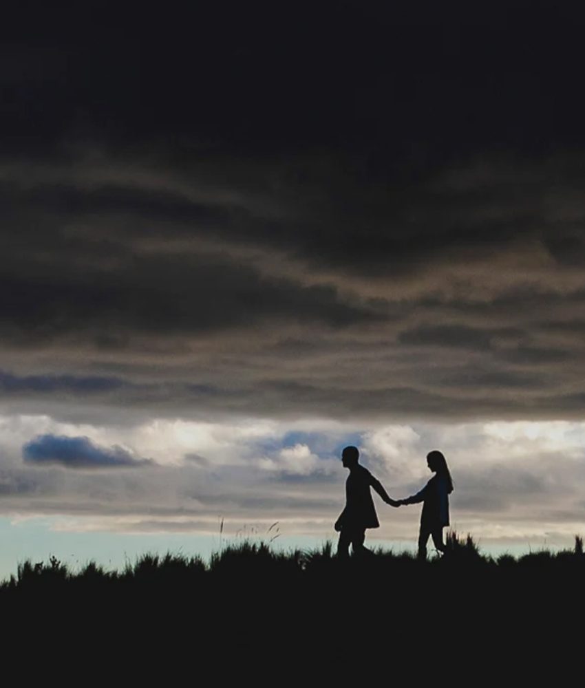 Couple walking under dramatic cloudy sky at Quito Teleferico Ecuador destination wedding photography