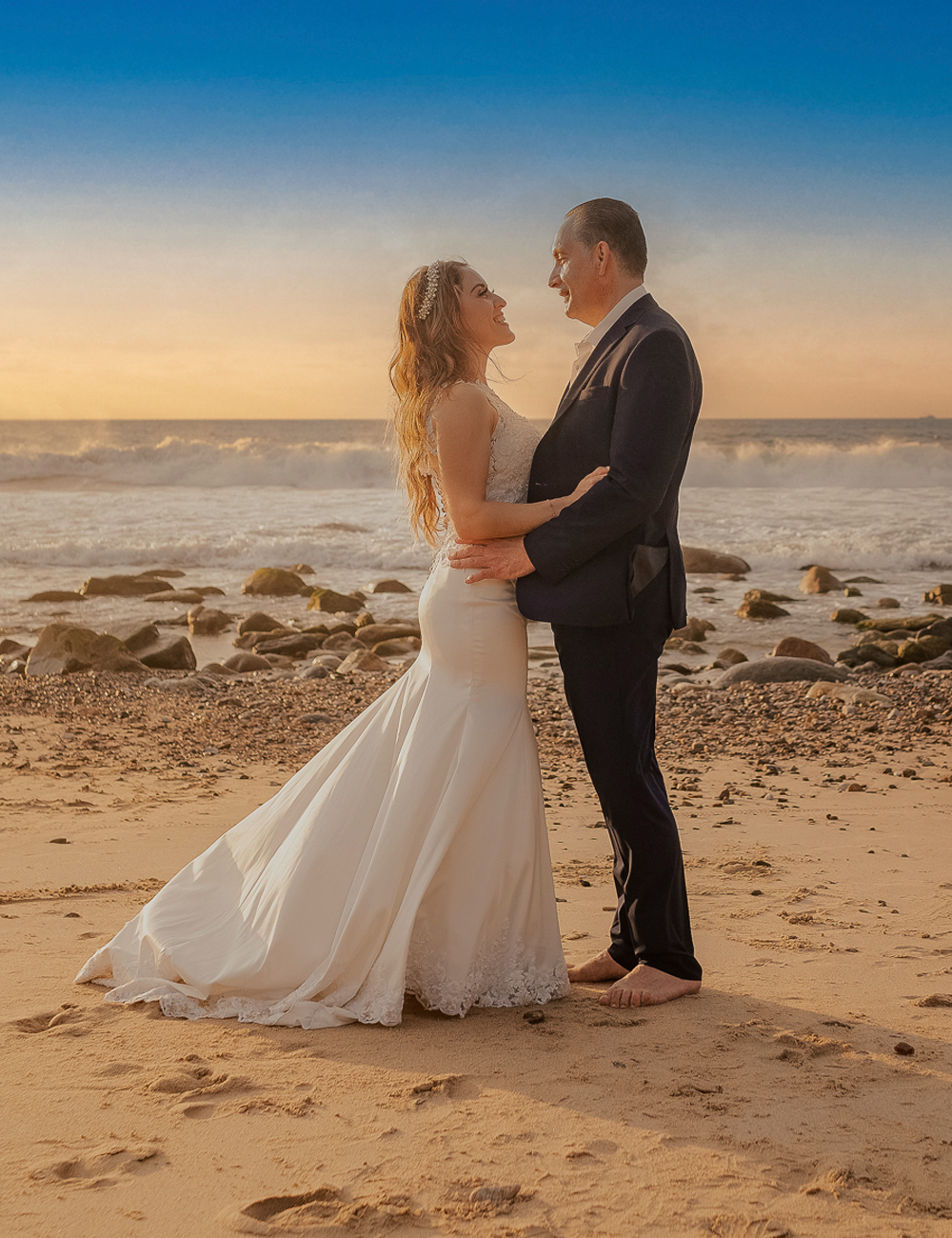 Bride and groom standing face to face by the ocean in Puerto Vallarta, intimate beach wedding moment